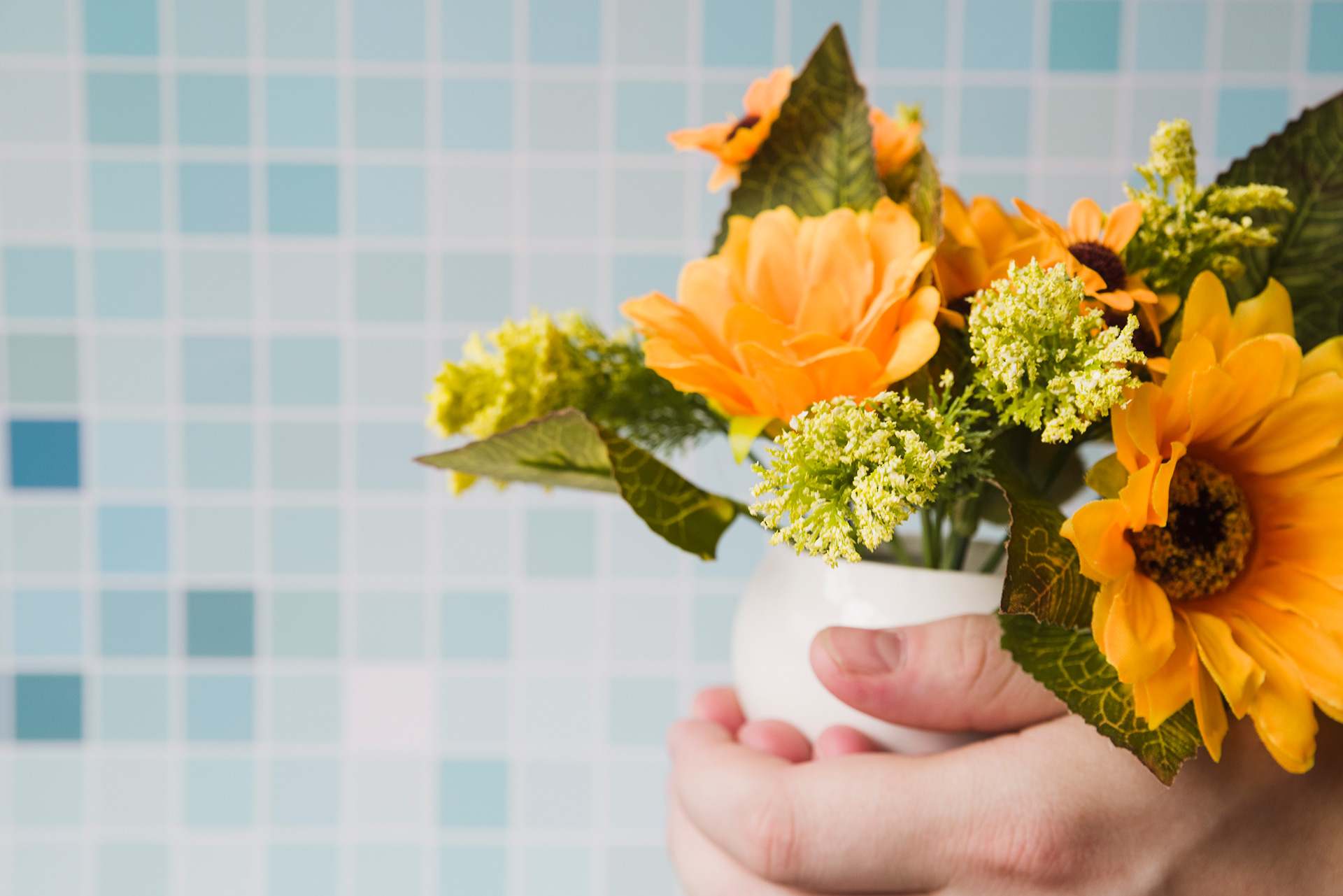 flower-vase-hand-against-mosaic-tiles